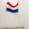 Vibrant Dutch flag in red, white, and blue, showcased against a simple background.