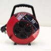 Red extension reel with 10m cable and four outlets for home and outdoor use.