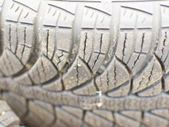 Close-up of a worn tire highlighting cracks and tread wear, essential for safe driving.