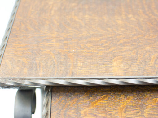 Handcrafted wooden table with twisted metal edge and wheels, blending elegance with versatility.