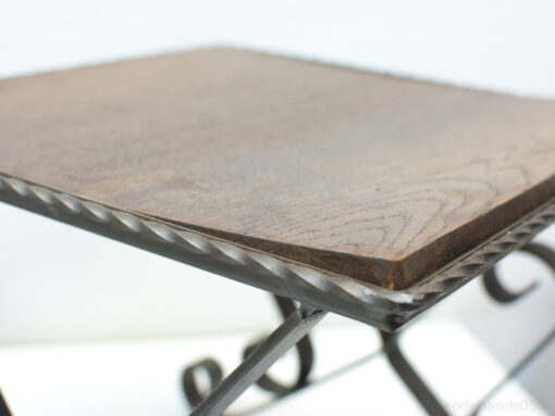 Elegant dark wood side table with artistic wrought iron base for stylish interiors.