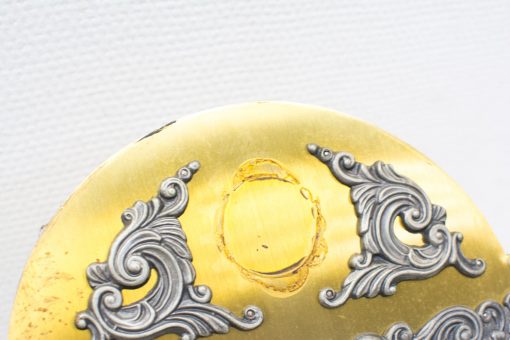 Elegant antique gold and silver medallion with intricate detailing, perfect for vintage decor.