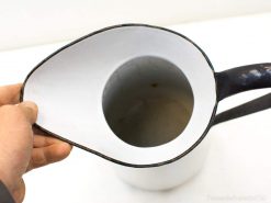 Elegant white pitcher with black trim, perfect for serving drinks and enhancing any decor.