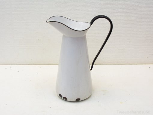 Charming vintage white pitcher with black handle, perfect for decor and daily use.