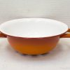 Vibrant orange ceramic bowl with glossy white interior and handles for stylish serving and mixing.
