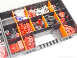 Colorful storage box for model building with wheels, gears, and versatile mechanical components.