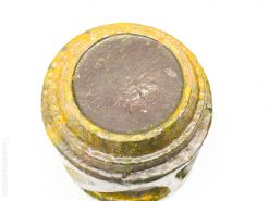 Vintage glass jar with yellow rim, showcasing unique texture and historical charm for collectors.