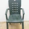 Durable dark green plastic chair with armrests, perfect for indoor and outdoor casual use.