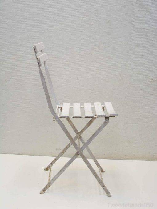 Stylish white folding chair with slatted design, ideal for modern indoor and outdoor spaces.