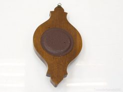 Elegant wooden wall decor with ceramic accent, enhancing vintage and modern interior styles.