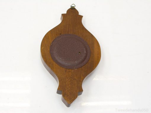 Elegant wooden wall decor with ceramic accent, enhancing vintage and modern interior styles.
