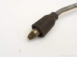 Vintage high-pressure connector with rubber grip, showing wear and character for restoration projects.
