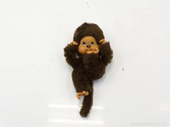 Playful vintage monkey plush doll with blue eyes and a cheerful smile, perfect for collectors.
