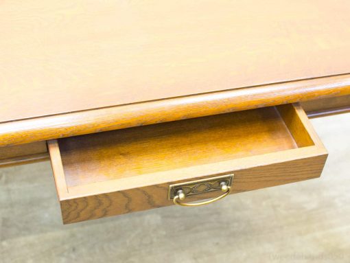 Elegant wooden desk with a brass handle, perfect for a stylish and functional workspace.
