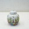 Elegant porcelain jar with vibrant floral and bee designs, perfect for decor and storage.