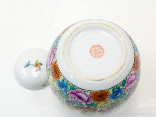 Beautiful porcelain jar with vibrant floral and butterfly designs, perfect for collectors and decor.
