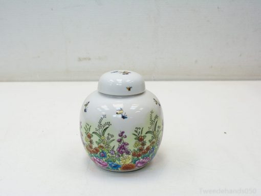 Elegant porcelain jar with vibrant floral and bee designs, perfect for decor and storage.