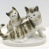 Charming porcelain cat figurine showcasing playful friendship, ideal for collectors and feline enthusiasts.