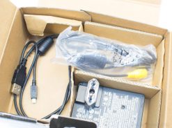 Vintage power adapter and cables in an organized box for optimal connectivity.