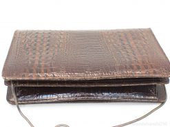 Luxurious brown leather clutch with crocodile pattern and versatile chain strap for any occasion.