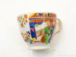 Elegant hand-painted porcelain cup featuring vibrant figures and floral designs, a charming collectible piece.