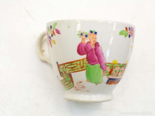 Colorful porcelain cup depicting a traditional woman and floral elements, ideal for decorative settings.