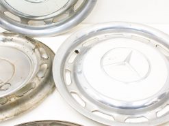 Vintage Mercedes-Benz hubcaps: polished elegance meets unique character from years of use.