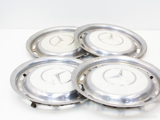 Set of four vintage Mercedes-Benz hubcaps with polished finish and classic three-pointed star logo.