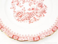 Antique porcelain plate with vibrant red floral designs and elegant gold trim for decor.