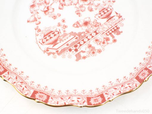 Antique porcelain plate with vibrant red floral designs and elegant gold trim for decor.