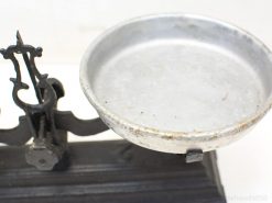 Vintage balance scale with cast iron base and aluminum pan, showcasing timeless craftsmanship.