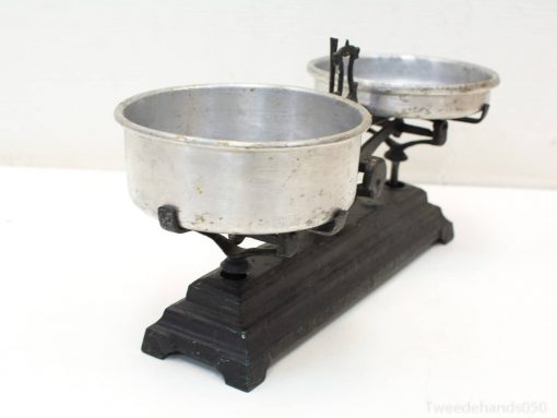 Antique balance scale with shiny pans, ideal for home decor or precise kitchen weighing.