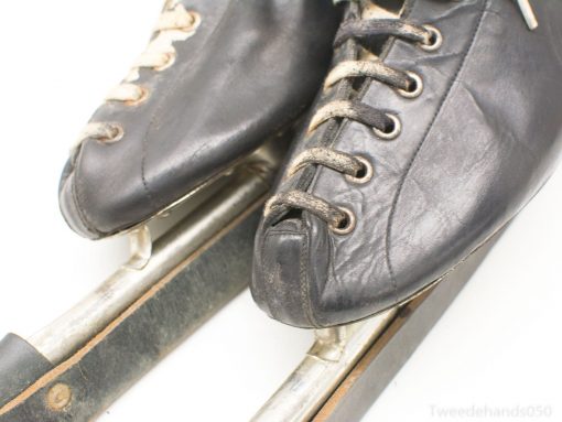 Vintage black ice skates with history, showcasing wear and charm for winter sports enthusiasts.