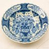 Elegant white ceramic bowl with intricate blue floral design and scalloped edges.