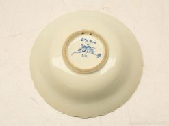Elegant scalloped porcelain bowl with creamy glaze and blue makers mark for decor or collection.
