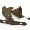 Antique doorbell with decorative bracket and unique bronze patina, enhancing vintage home decor.