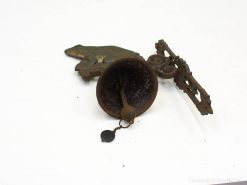 Antique bell, whimsical frog figure, and ornate metal bracket for vintage home decor.