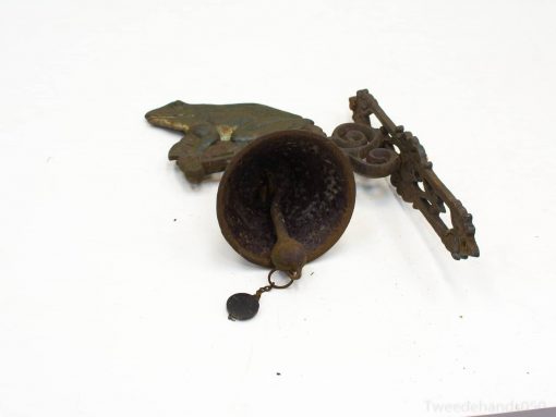 Antique bell, whimsical frog figure, and ornate metal bracket for vintage home decor.