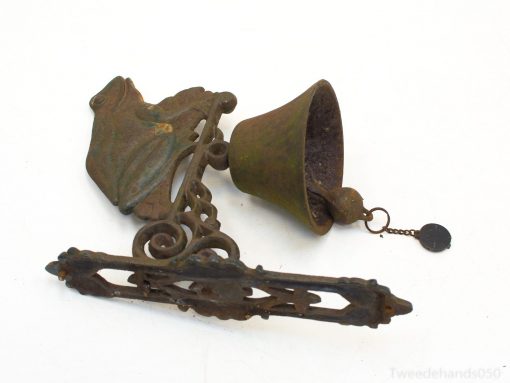 Antique doorbell with decorative bracket and unique bronze patina, enhancing vintage home decor.