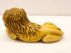 Stylish reclining lion sculpture with rich details, symbolizing strength and tranquility in warm hues.