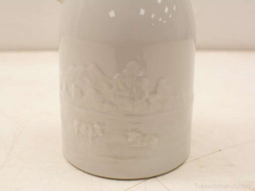Elegant gray ceramic pitcher featuring serene landscape relief for decor and practical use.