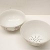 Elegant porcelain mixing bowl and colander with floral design for stylish kitchen use.