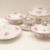 Elegant porcelain dish set with pink flowers and gold trim for refined dining experiences.