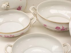 Elegant porcelain dishware with pink flowers and gold trim, perfect for sophisticated dining occasions.