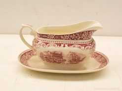 Elegant vintage cream jug and saucer set with intricate floral print design.