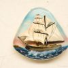 Vintage sailing ship decor with intricate waves, perfect for nautical enthusiasts and collectors.