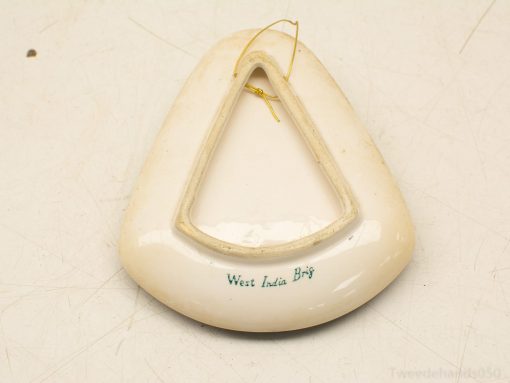 Triangular porcelain decoration with West India inscription, featuring a glossy finish and hanging wire.