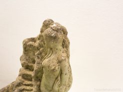 Elegant stone sculpture of a woman, embodying feminine grace and a bond with nature.