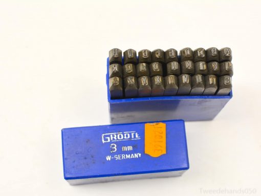Vintage metal stamping tools in a blue case, perfect for crafting and labeling projects.