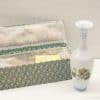 Elegant porcelain vase with floral designs next to a stylish decorative box.